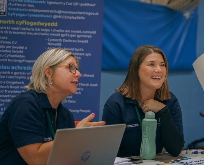 Staff interacting at the Abergavenny Jobs fair and supporting. Llun o staff yn Ffair Swyddi Y Fenni yn rhoi gymorth.